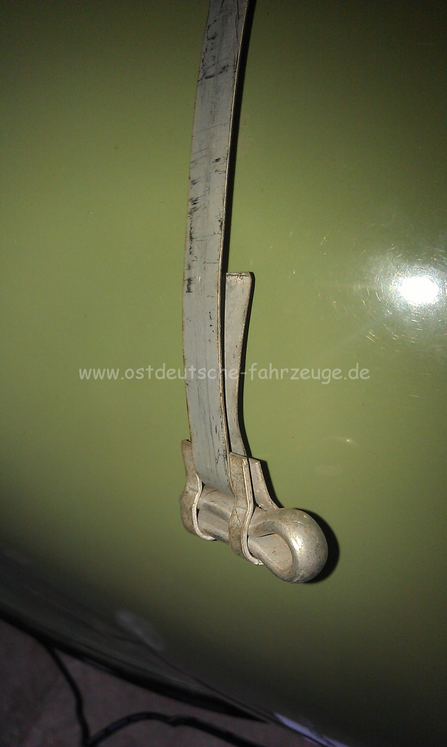 Dann wird das Spannstück eingehängt. das Umgebogene Stück des Bandes liegt später innnen an der Leitung an.